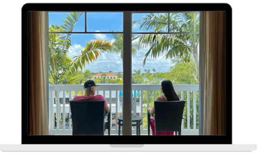 A couple sitting in a patio outside by the palm trees in West Palm Beach, Florida